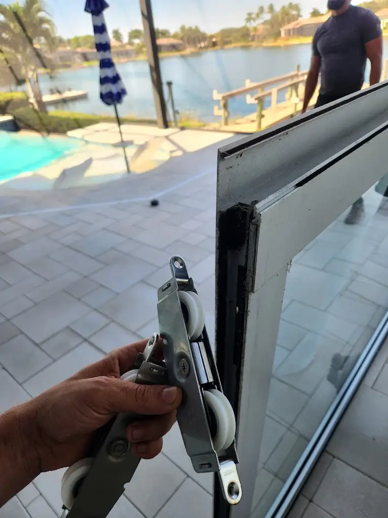 Nexora technician holding a new sliding door roller assembly before installation at a Southwest Florida home